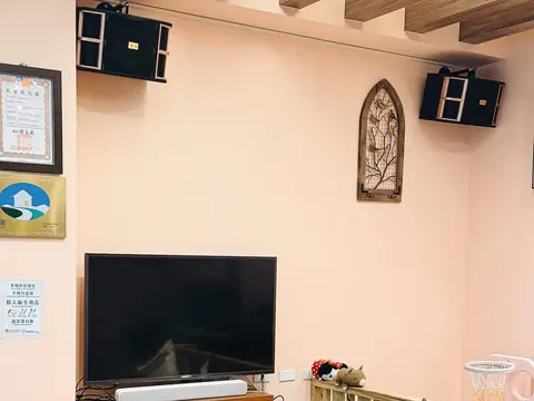 心想事成的 KTV 區，牆上掛著兩支卡拉OK喇叭，下方是點歌用的大電視
