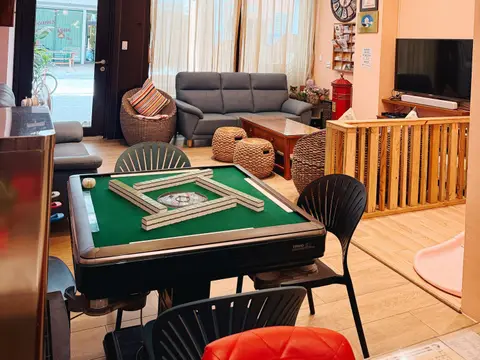 心想事成的電動麻將桌，自動洗牌機台已經把牌堆好，旁邊就是沙發客廳與兒童溜滑梯